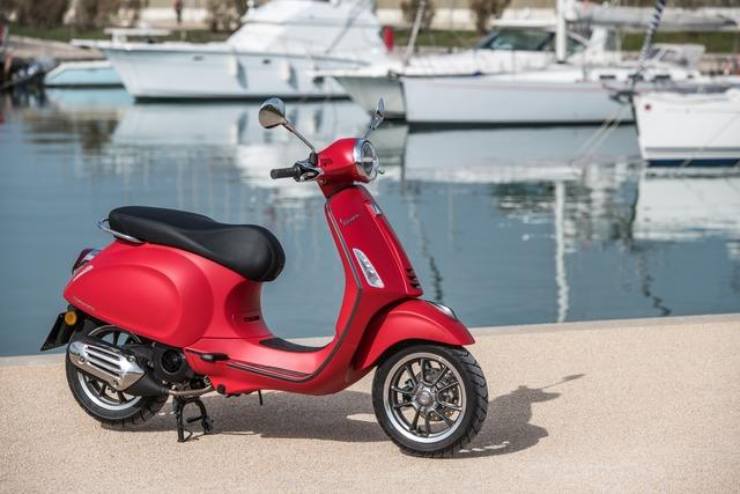 uno scooter di colore rosso con dietro il mare
